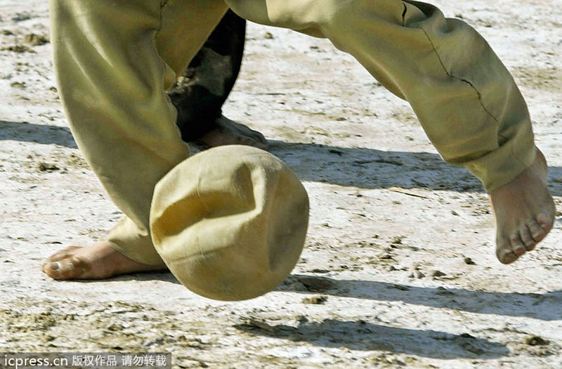 An Iraqi boy plays football in Diwanya, 180 kms South of Baghdad, March 28, 2004. Public sports in post-war Iraq