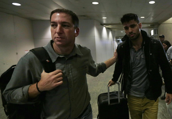 US journalist Glenn Greenwald (L) walks with his partner David Miranda in Rio de Janeiro's International Airport August 19, 2013.  Snowden reporter to publish UK secrets